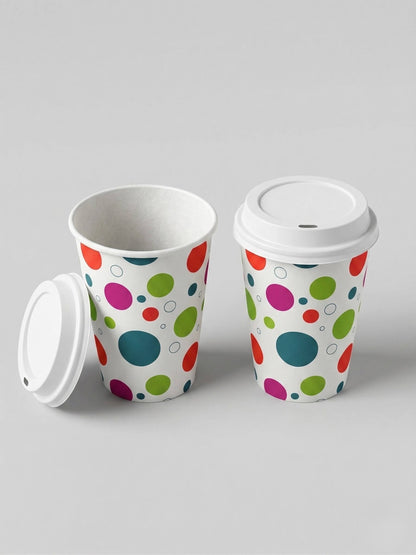 Two Axxion 12-ounce disposable paper cups featuring a polka dot pattern, displayed against a light grey background. One cup has a white travel lid securely attached, while the other is open with its lid leaning against the base. These sets are packaged in 6-count packs and distributed as 288 per case.